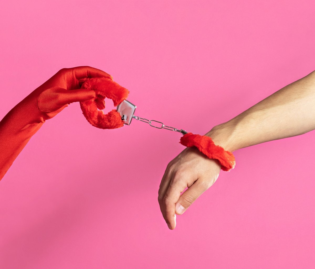 Hands clasped by fluffy handcuffs
